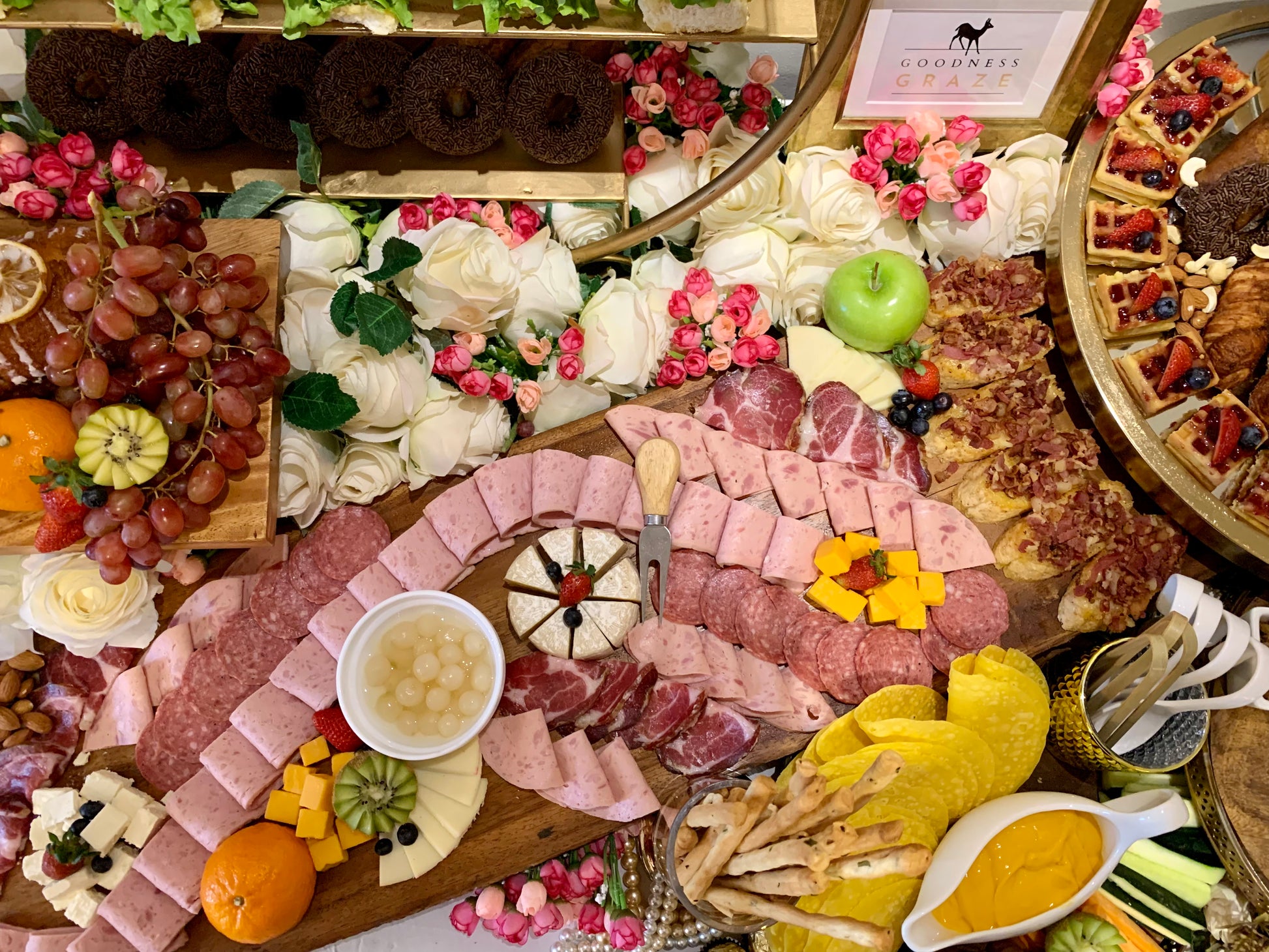 Grazing table with cheeses, cold cuts, fruits, nuts, and other treats